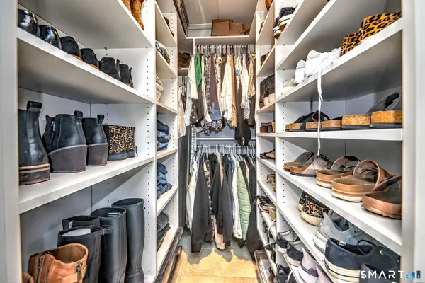 a view of walk in closet with clothes and shoes