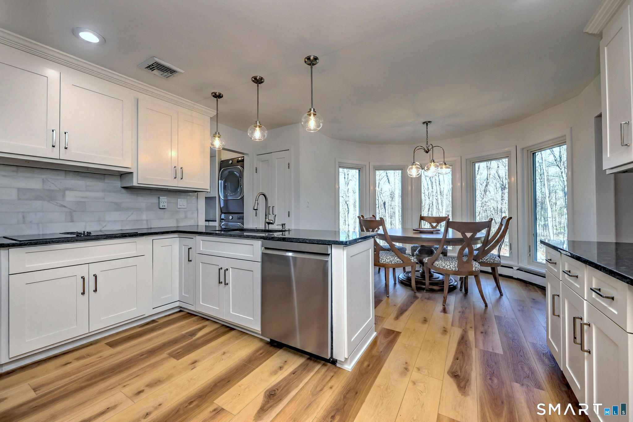 48 Nancy Drive Monroe, CT 06468 - Photo 9 of 38 a kitchen with stainless steel appliances granite countertop wooden floor a dining table chairs and white cabinets