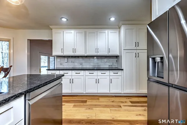 a kitchen with stainless steel appliances granite countertop a refrigerator sink and cabinets