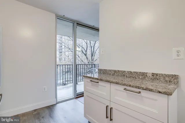 a kitchen with granite countertop white cabinets and white appliances