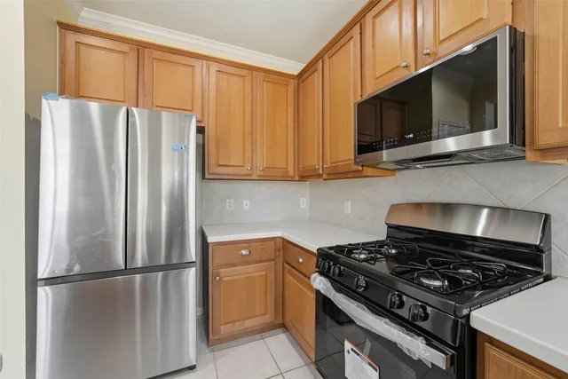 a kitchen with stainless steel appliances granite countertop a refrigerator stove and microwave