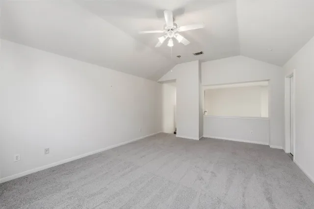 an empty room with chandelier fan