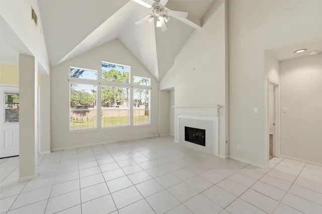 an empty room with windows and fireplace