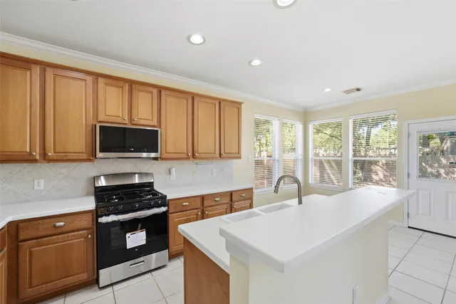 a kitchen with stainless steel appliances granite countertop a stove a sink and a microwave