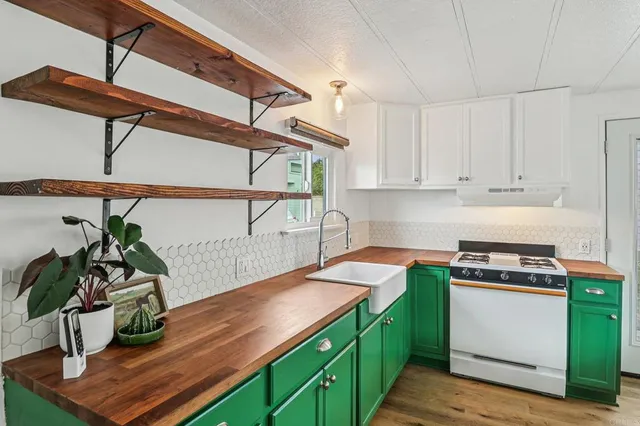 a kitchen with kitchen island a stove cabinets and wooden floor