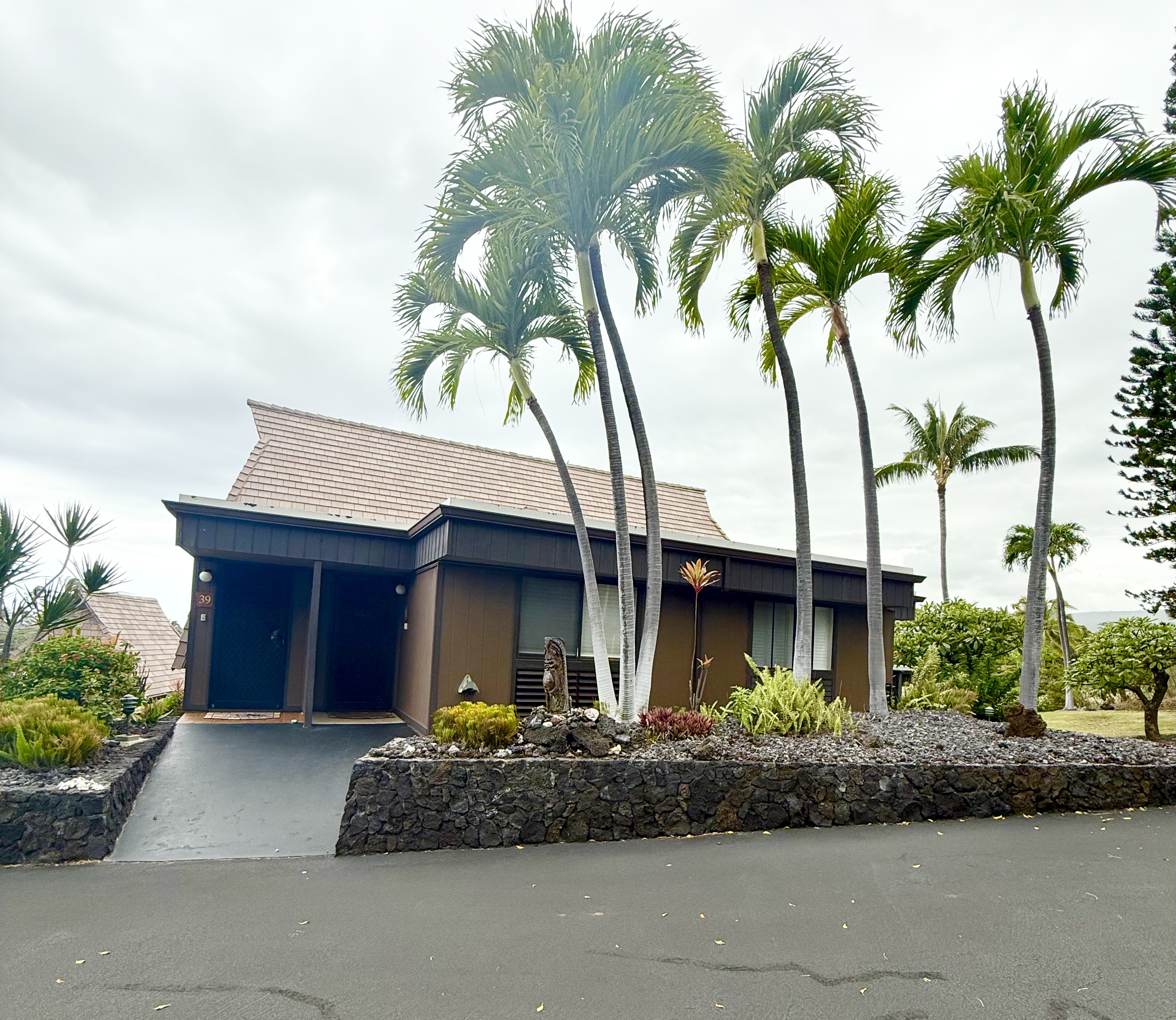 95-788 Ninole Loop Road, Unit 39 Naalehu, HI 96772 - Photo 15 of 15 a front view of a house with a garden