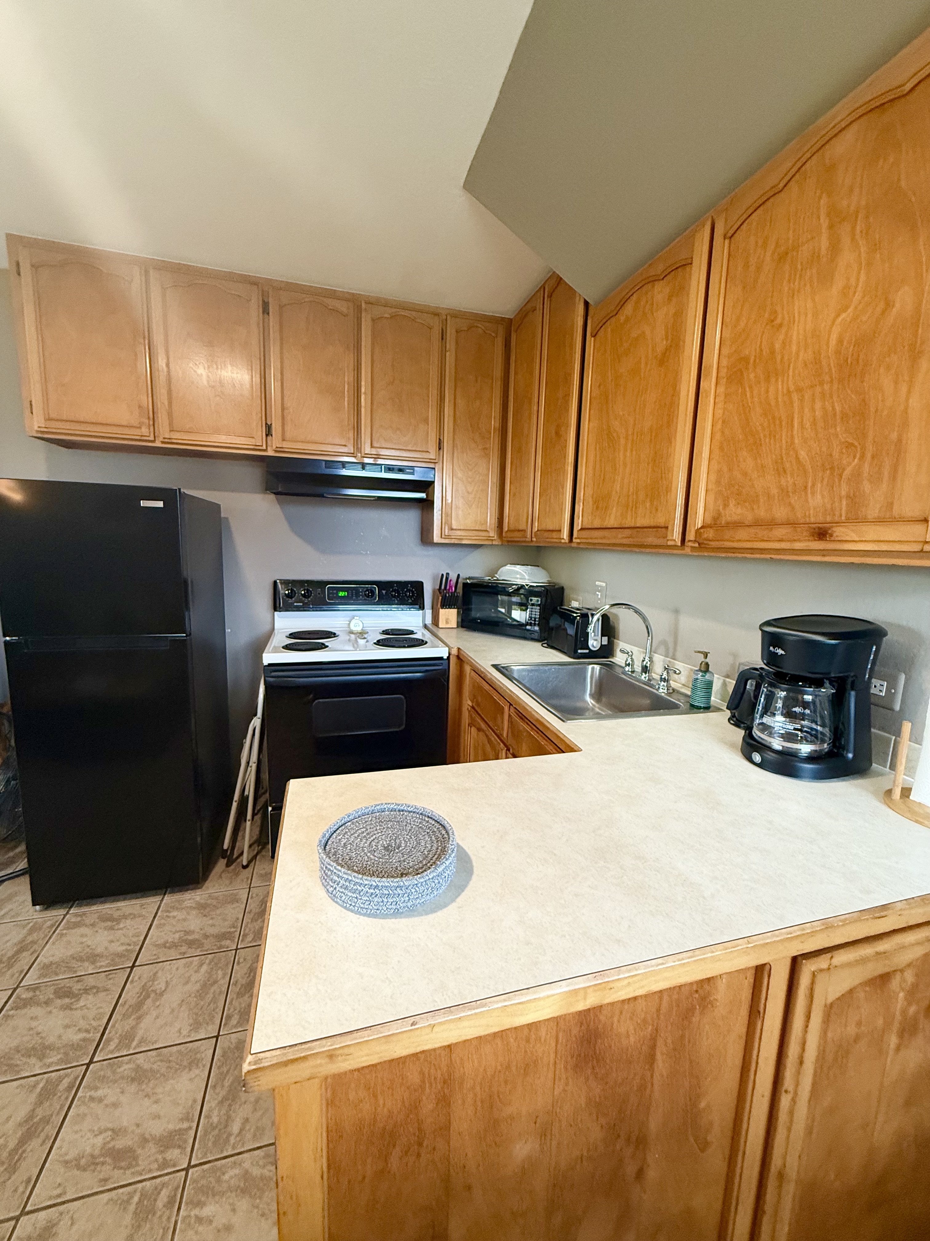 95-788 Ninole Loop Road, Unit 39 Naalehu, HI 96772 - Photo 6 of 15 a kitchen with a sink a stove and cabinets