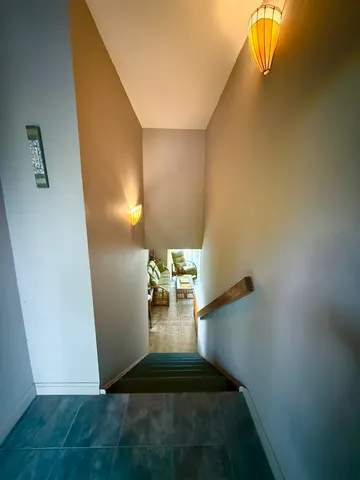 a view of a livingroom with wooden floor and a staircase