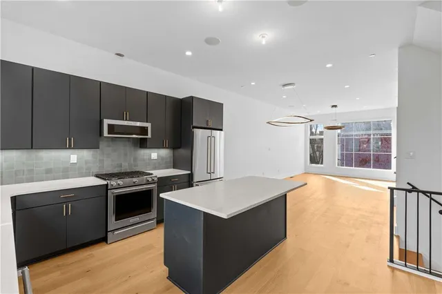 a large kitchen with stainless steel appliances granite countertop a stove and a sink