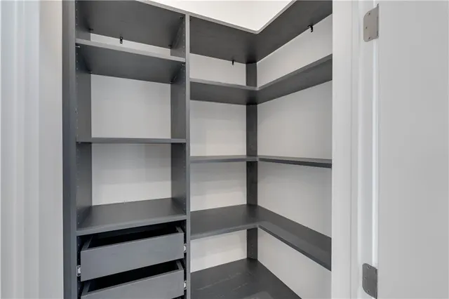 a view of walk in closet with empty racks