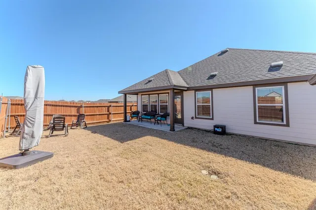 a view of a house with backyard and sitting area