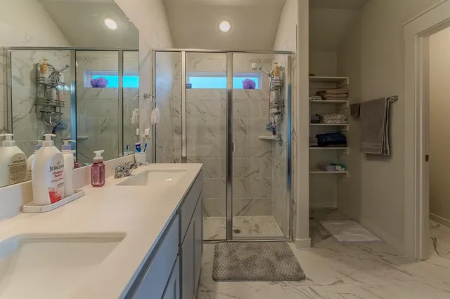 a bathroom with a shower sink and mirror
