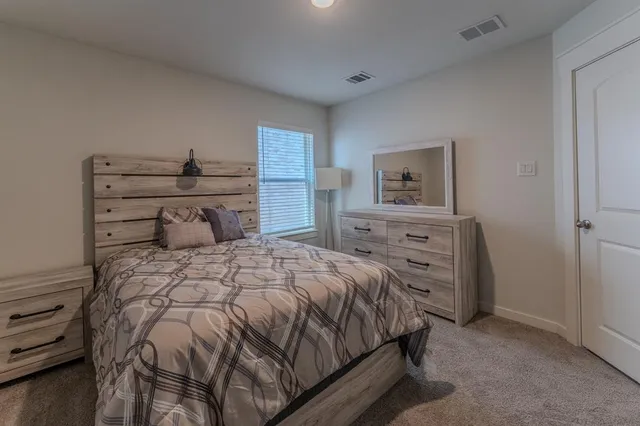 a bedroom with a bed and a dresser
