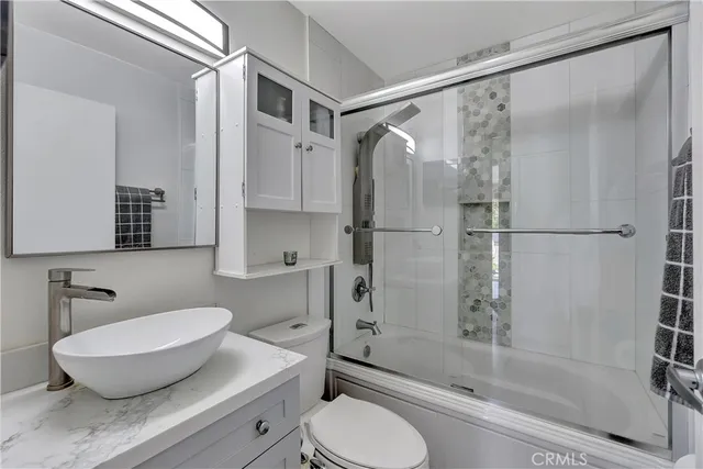 a bathroom with a granite countertop sink toilet and shower