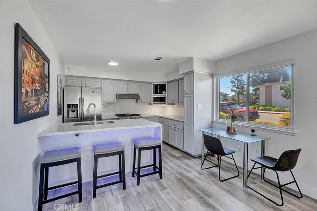 a kitchen with a table chairs and wooden floor