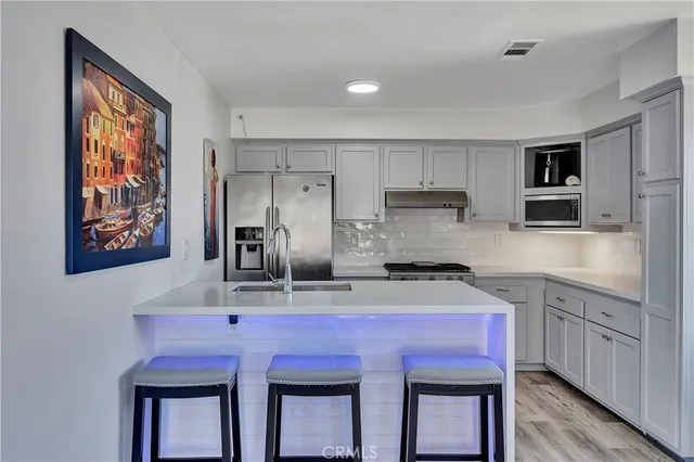 a kitchen with stainless steel appliances a sink stove and refrigerator