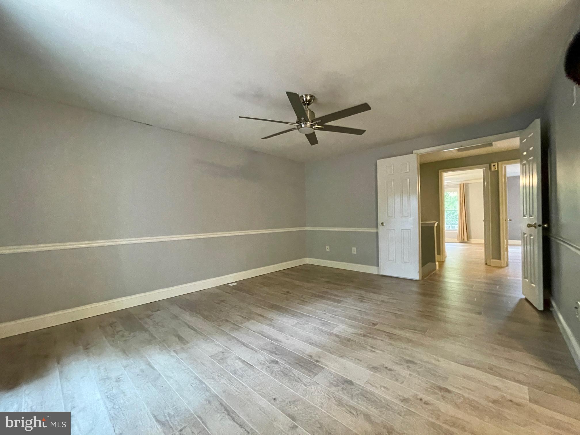 308 Crescendo Way Silver Spring, MD 20901 - Photo 18 of 26 a view of a livingroom with wooden floor and a ceiling fan