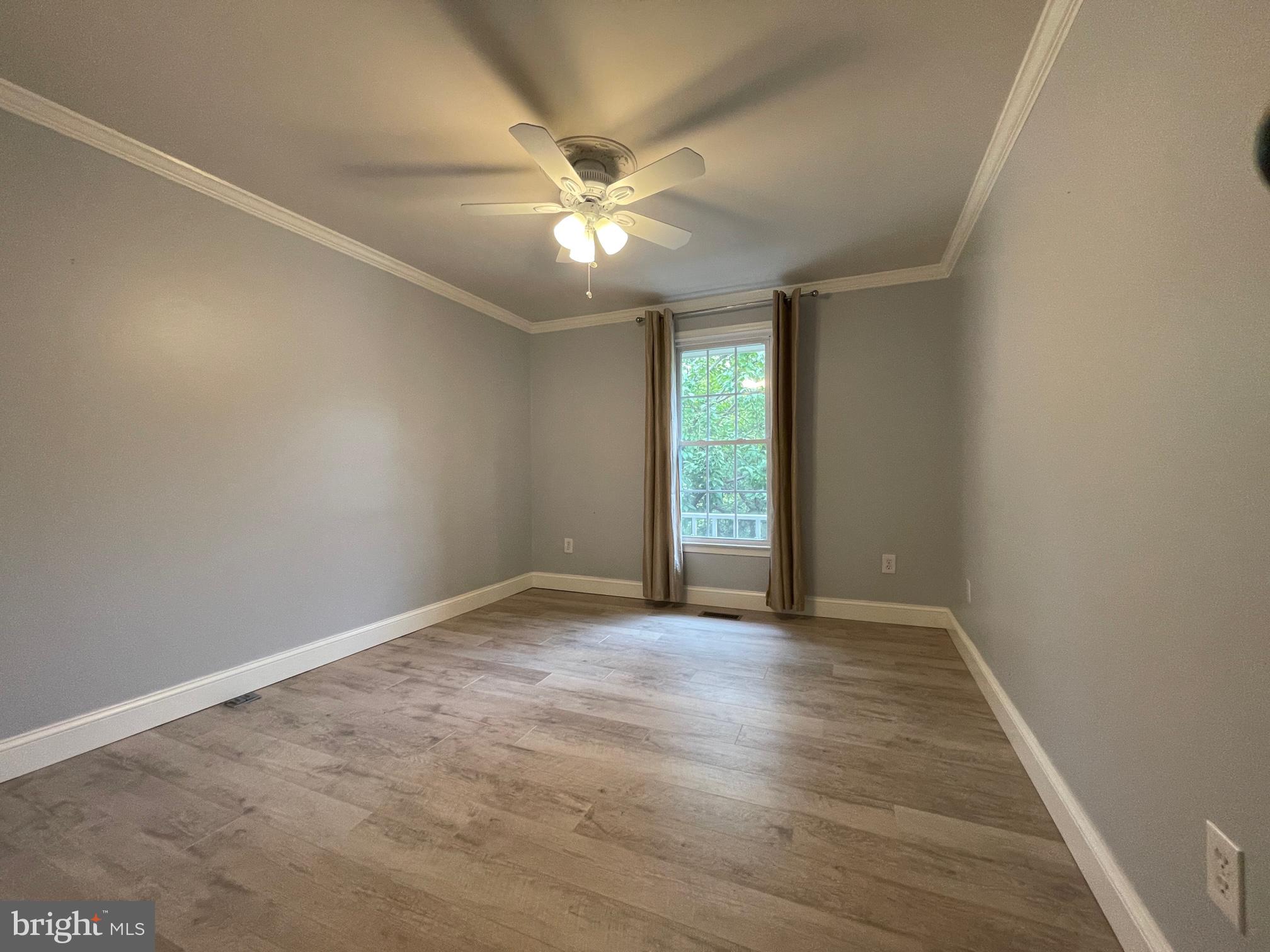 308 Crescendo Way Silver Spring, MD 20901 - Photo 25 of 26 an empty room with wooden floor fan and windows