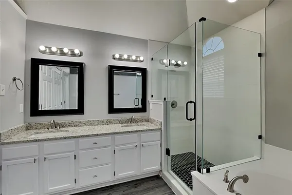 a bathroom with double sink and a mirror