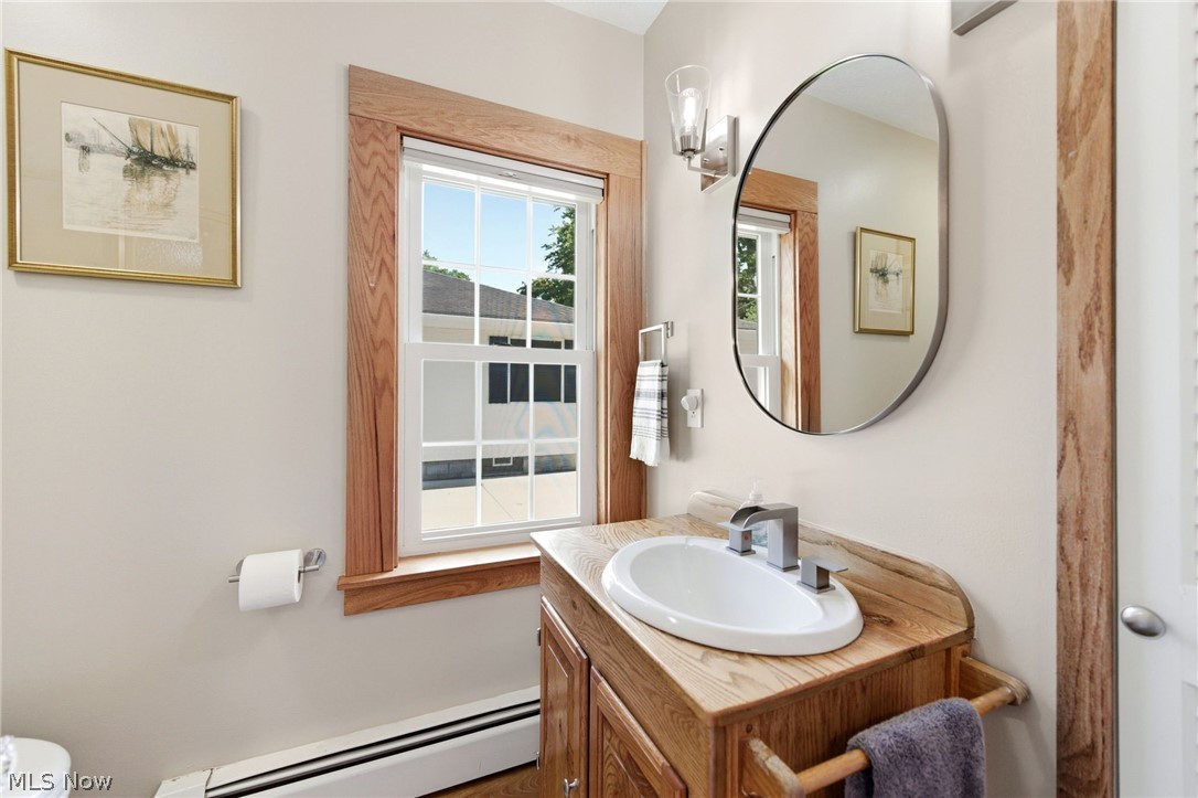 233 Sunset Road Avon Lake, OH 44012 - Photo 26 of 50 Bathroom featuring a wood-finish vanity with an integrated sink, a contemporary mirror, and a wall-mounted light fixture and a walk in shower