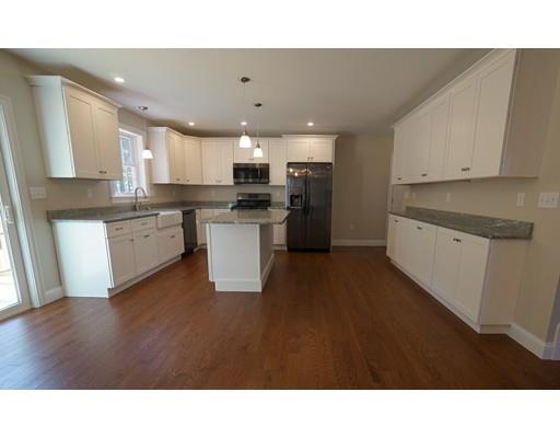 10 Rileys Way Pepperell, MA 01463 - Photo 3 of 7 a open kitchen with stainless steel appliances kitchen island a sink dishwasher a stove with wooden cabinets