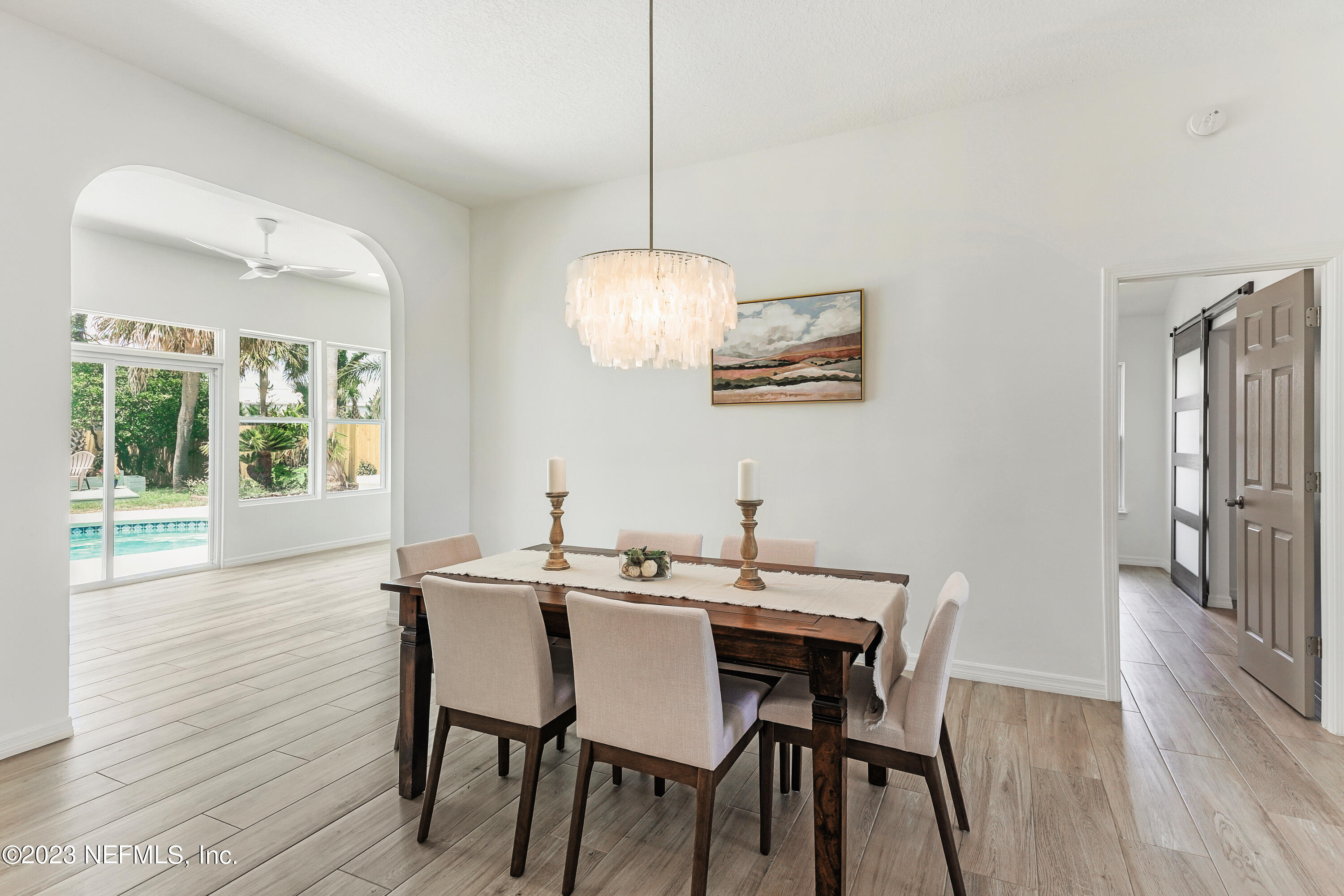627 Cherry Street Neptune Beach, FL 32266 - Photo 12 of 51 a dining room with wooden floor a chandelier a wooden table and chairs