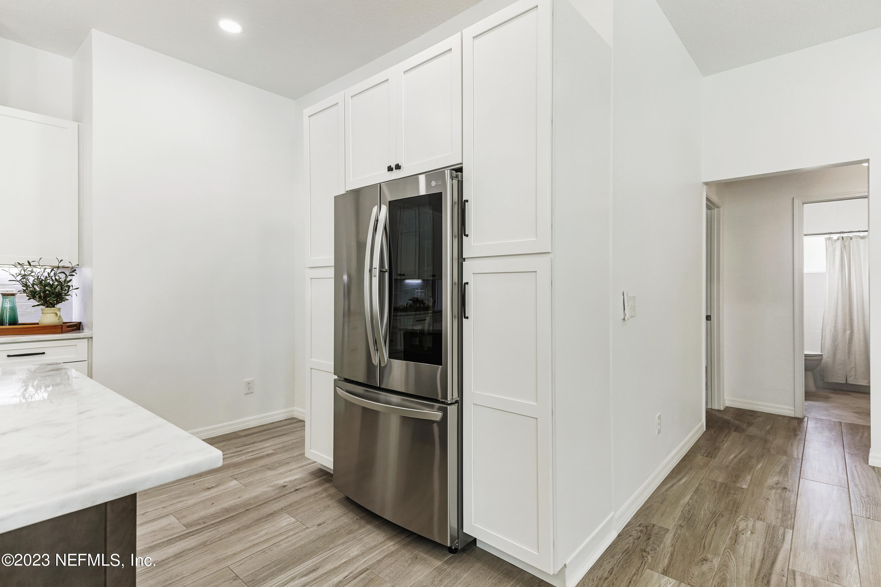 627 Cherry Street Neptune Beach, FL 32266 - Photo 13 of 51 a view of a kitchen with refrigerator and wooden floor