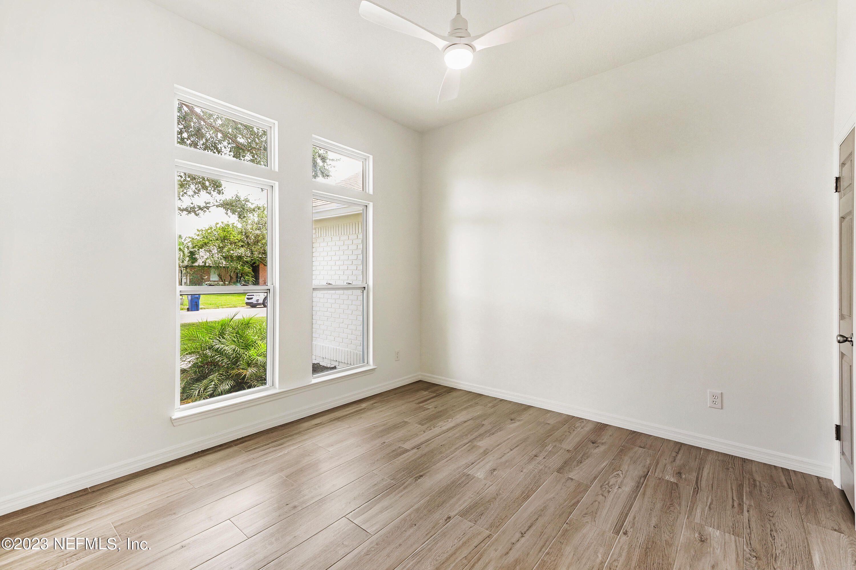 627 Cherry Street Neptune Beach, FL 32266 - Photo 38 of 51 an empty room with wooden floor and windows