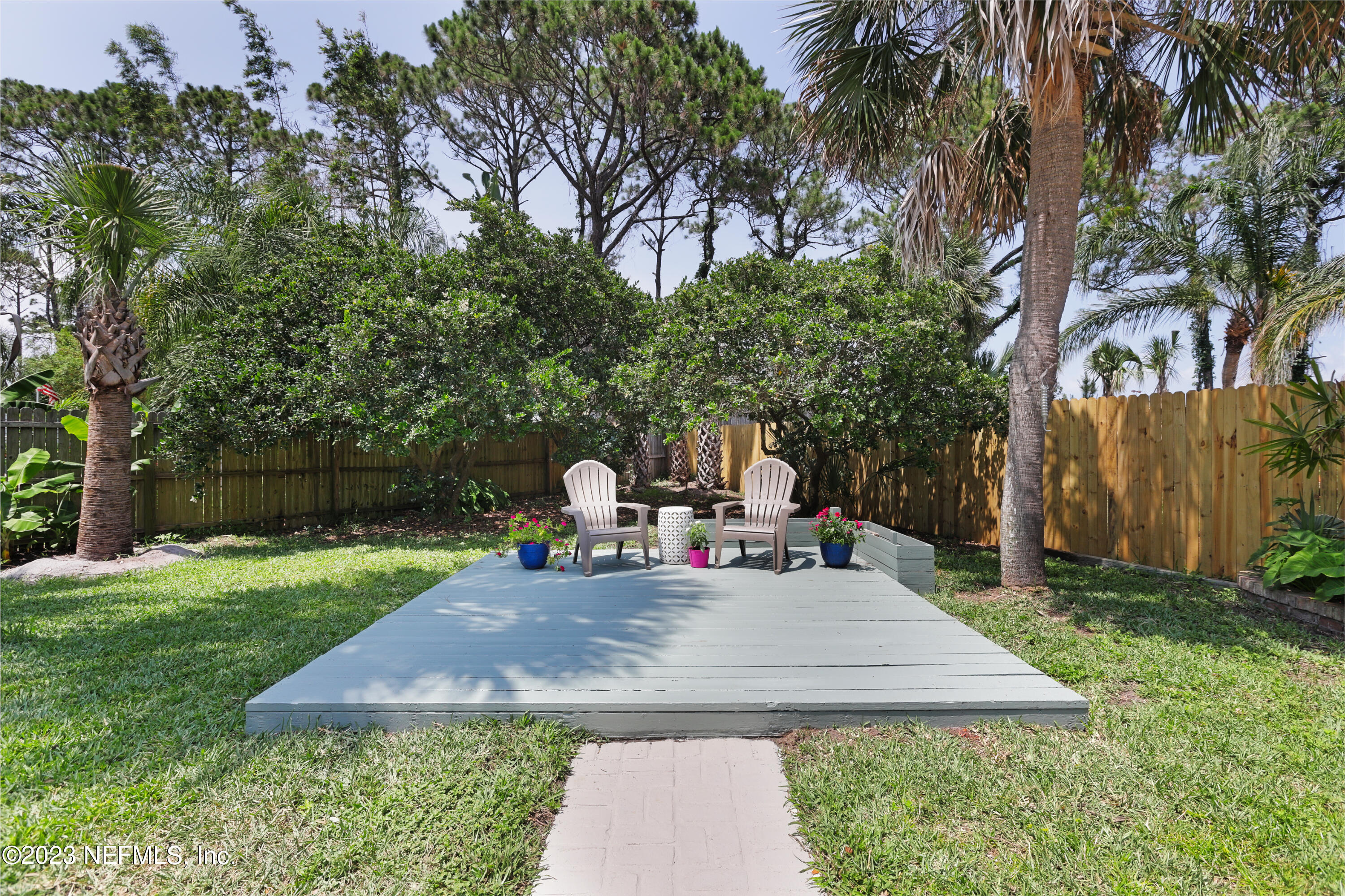 627 Cherry Street Neptune Beach, FL 32266 - Photo 46 of 51 a view of a backyard with table and chairs plants and trees
