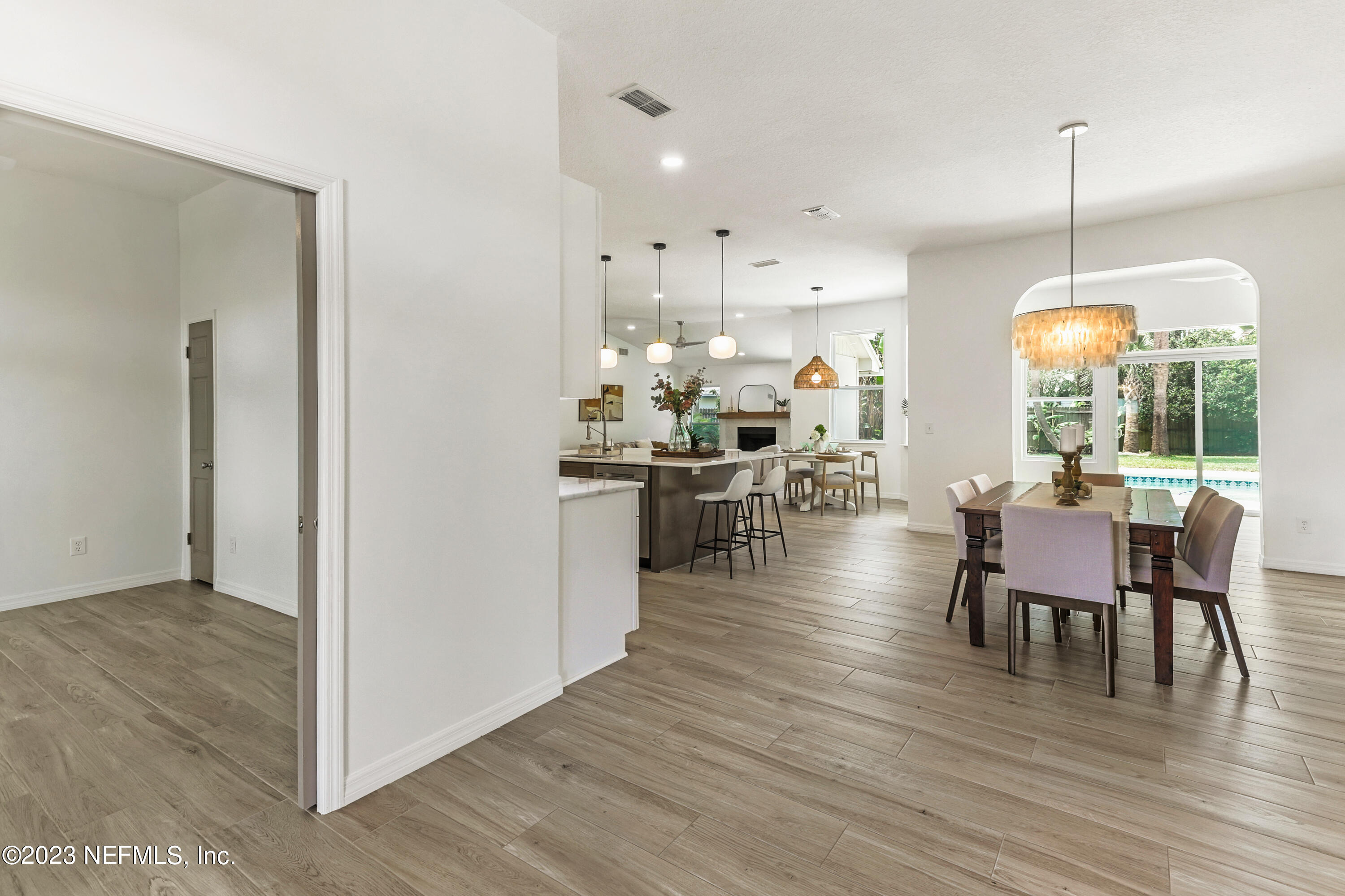 627 Cherry Street Neptune Beach, FL 32266 - Photo 6 of 51 a view of a dining room and livingroom with furniture wooden floor a chandelier