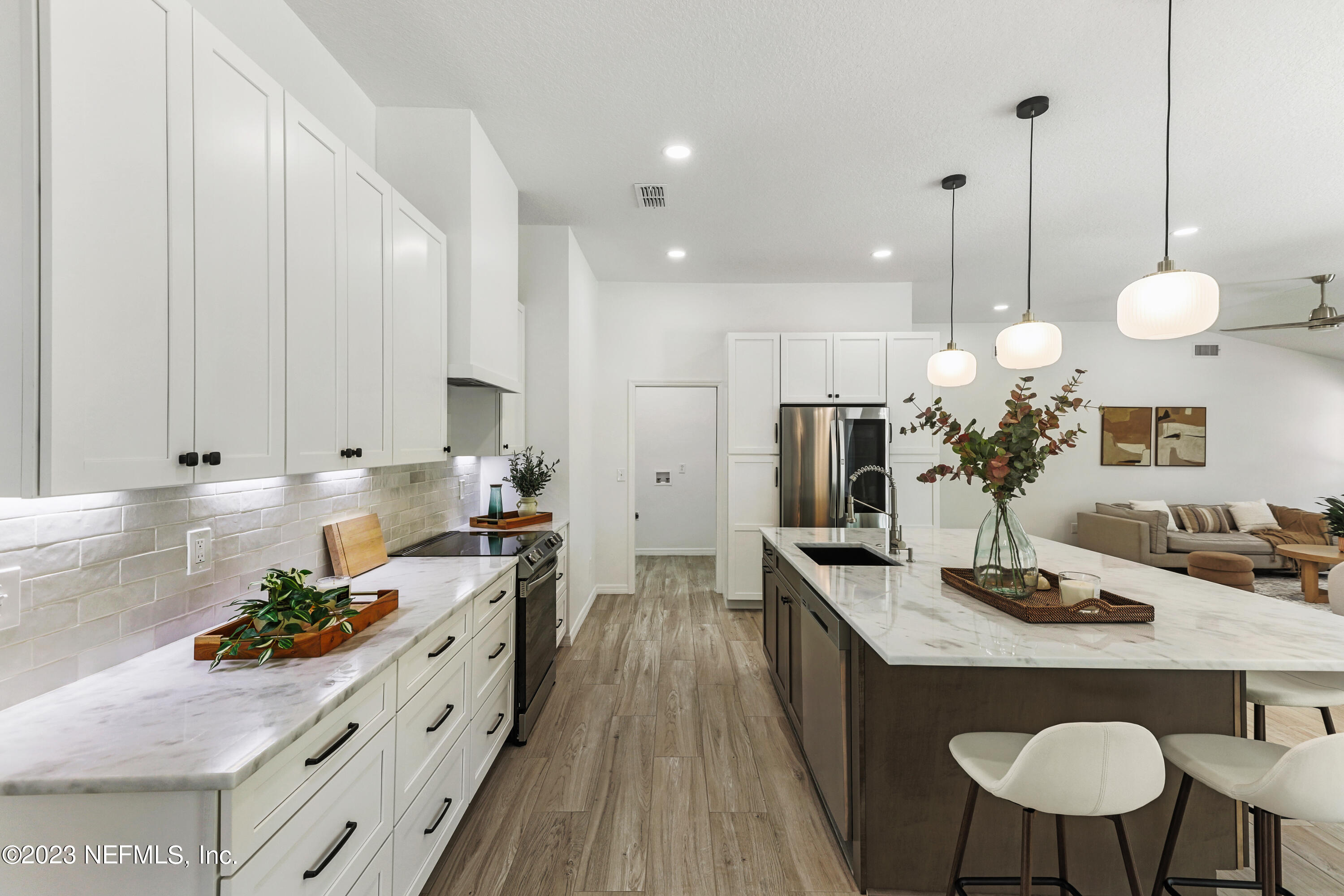 627 Cherry Street Neptune Beach, FL 32266 - Photo 8 of 51 a kitchen with granite countertop a sink stove and white cabinets with wooden floor