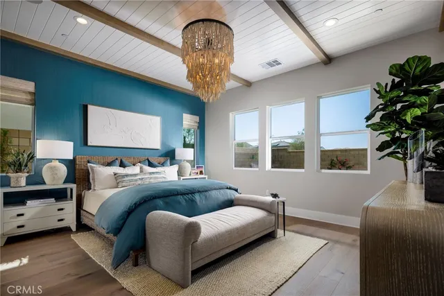 a bedroom with a large bed and a chandelier