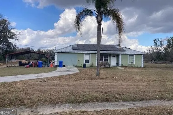 a front view of a house with a garden and trees