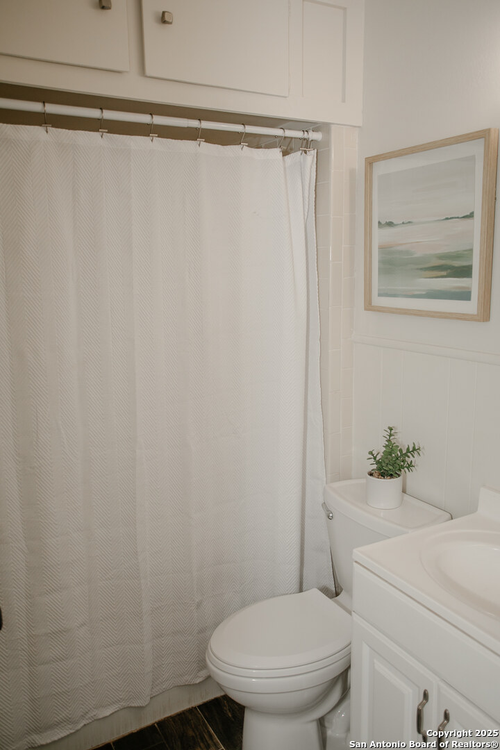 456 Margo Drive Pearsall, TX 78061 - Photo 23 of 40 a white toilet sitting next to a shower curtain