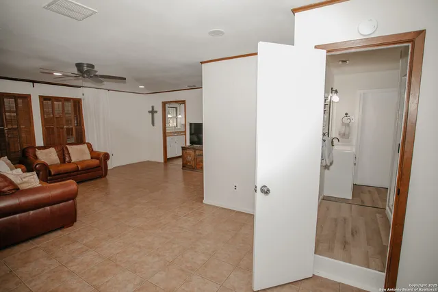a living room with furniture and a hallway