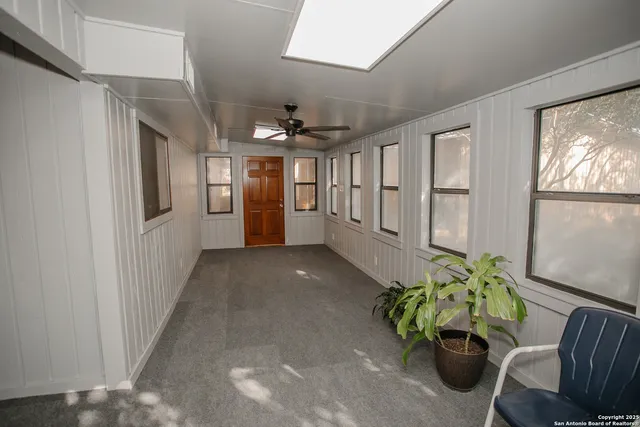 a view of a hallway with furniture and a potted plant