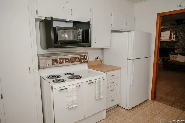 a kitchen with white cabinets and white appliances