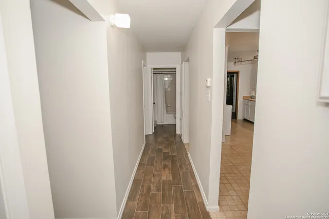 a view of a hallway with wooden floor and closet