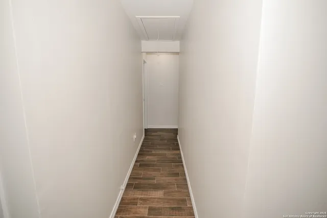 a view of a hallway with wooden floor