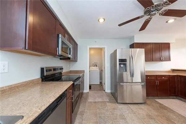 a kitchen with stainless steel appliances granite countertop a refrigerator a sink a stove and dishwasher