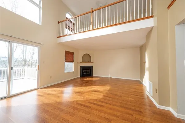 a view of empty room with wooden floor and fireplace