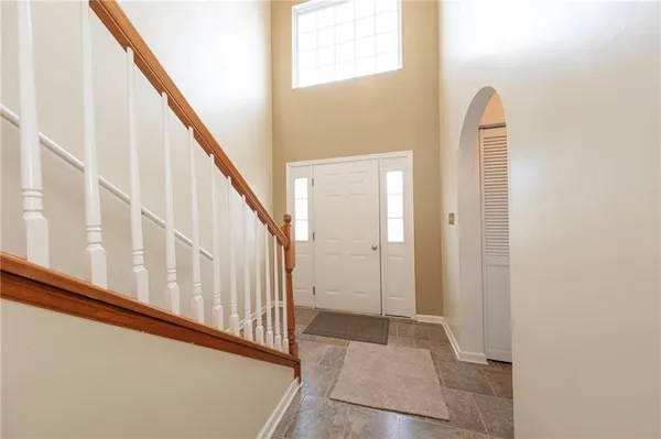 a view of staircase with lots of frames on wall and a window