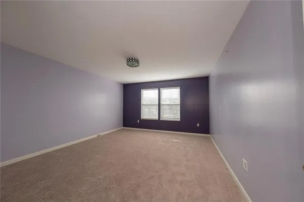 a view of a big room with windows and chandelier fan
