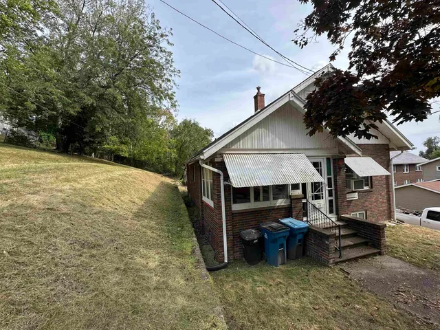 a view of house with backyard and sitting area