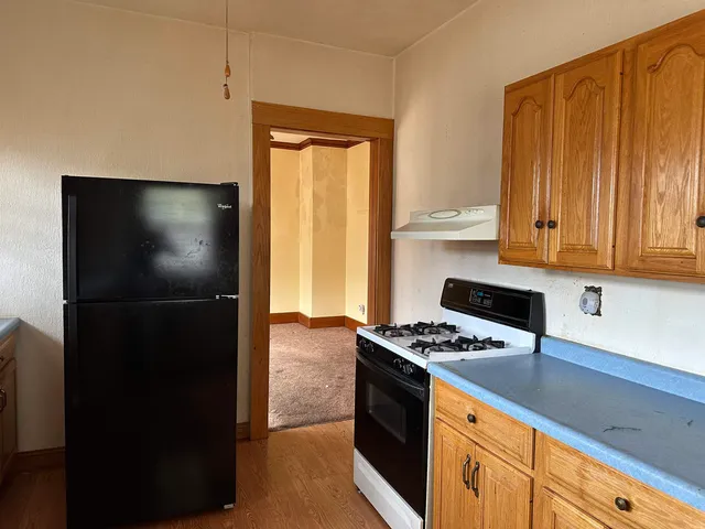 a kitchen with granite countertop a refrigerator and a stove top oven