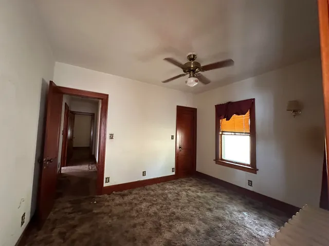 a view of a livingroom with a chandelier fan and a window