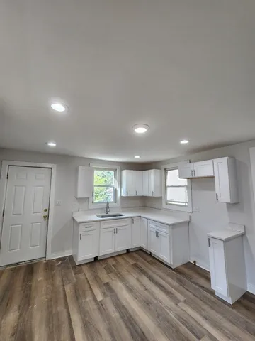 a large kitchen with cabinets and a wooden floors