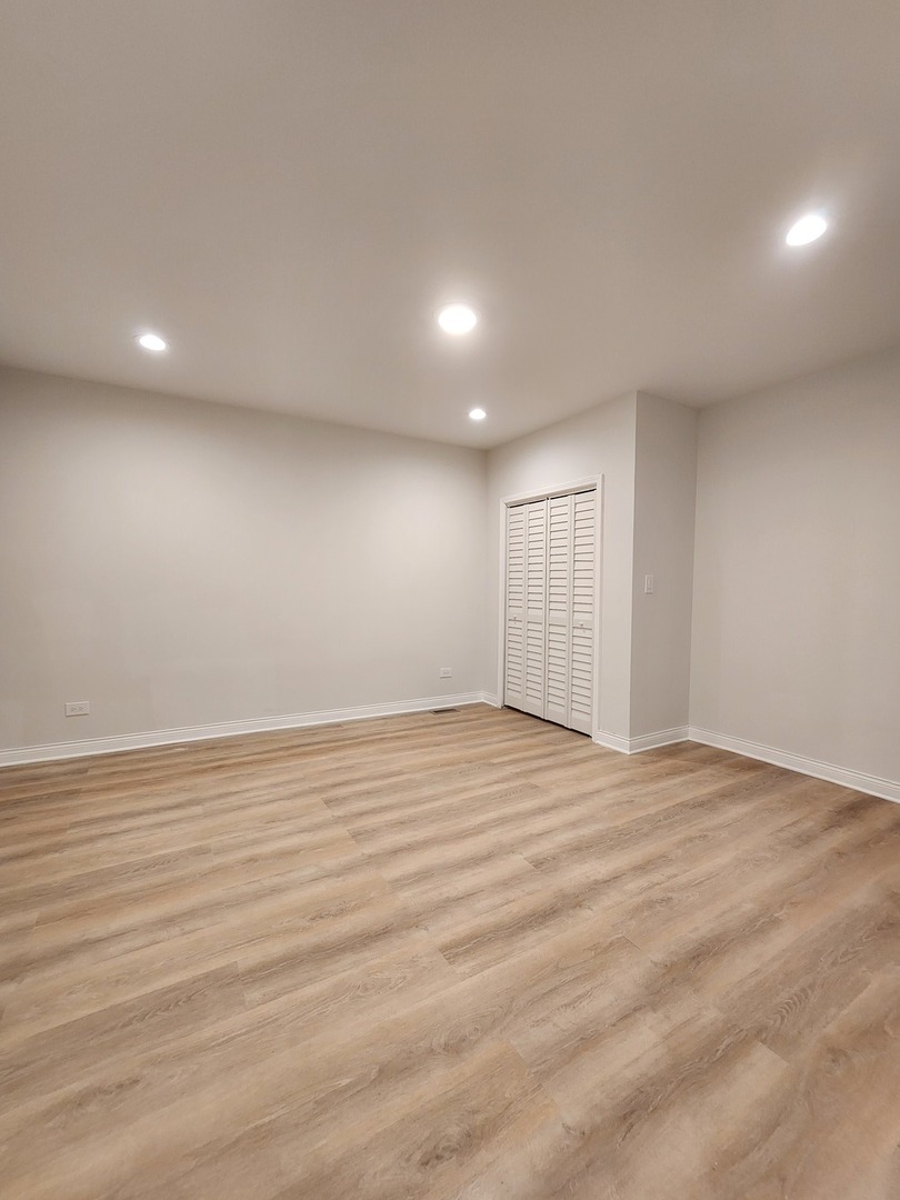 8900 South Normal Avenue Chicago, IL 60620 - Photo 19 of 28 an empty room with wooden floor and windows