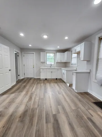 a view of kitchen with wooden floor and electronic appliances