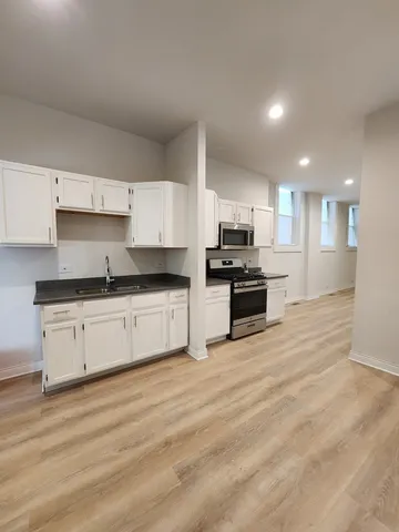 a large kitchen with granite countertop a stove and a sink